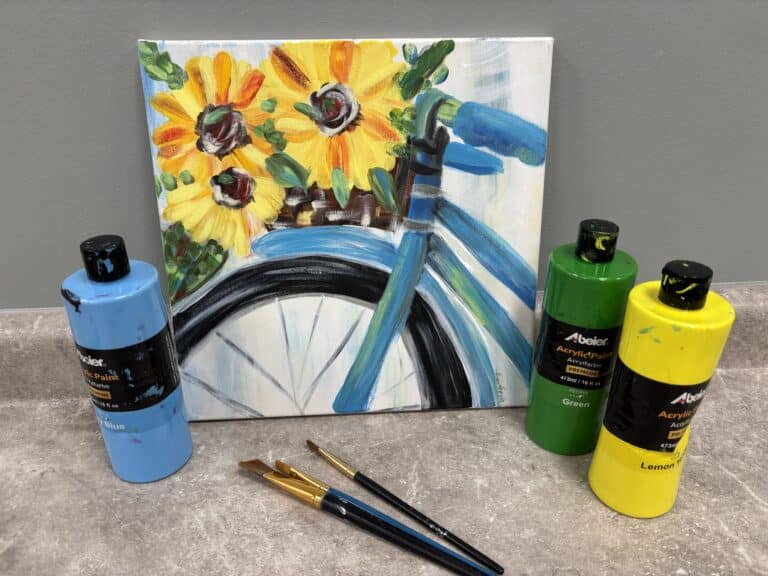 Finished bicycle-and-sunflowers canvas displayed beside Abeier acrylic paints and brushes