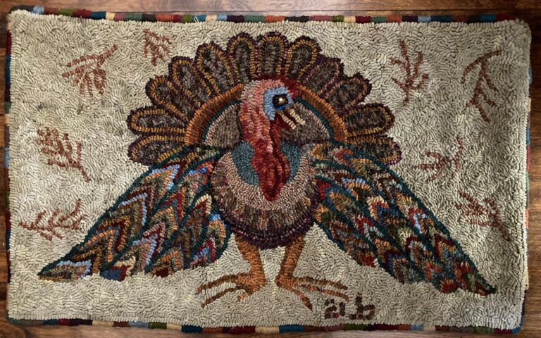 Hand-hooked rug featuring a colorful turkey with fanned tail, surrounded by autumn leaf motifs