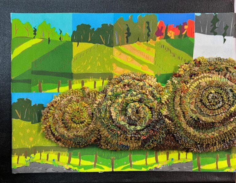 Fiber art hay bales crafted from coiled, textured yarn rest against a colorful painted landscape canvas backdrop