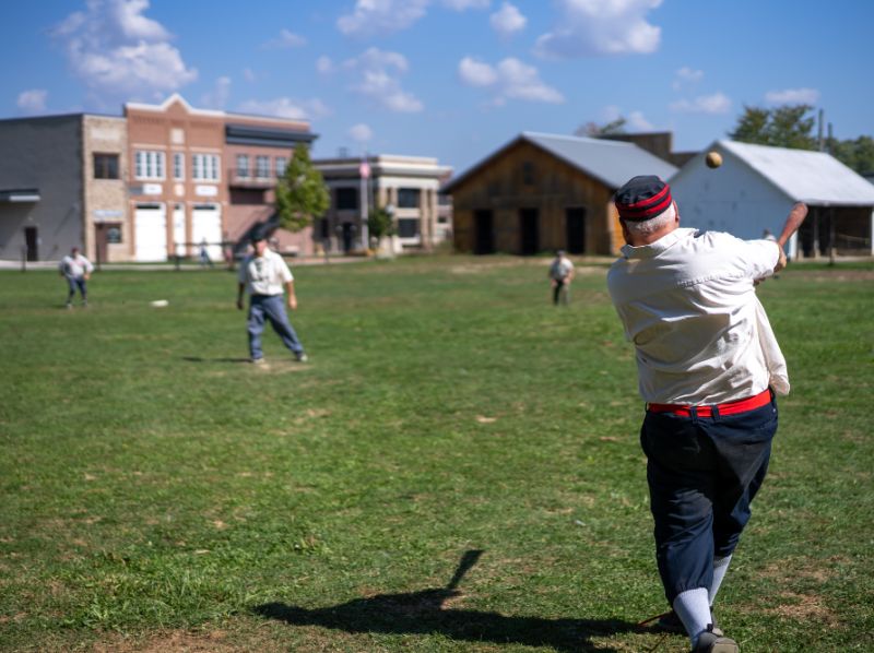 Vintage base ball batter swinging on the Sauder Village green