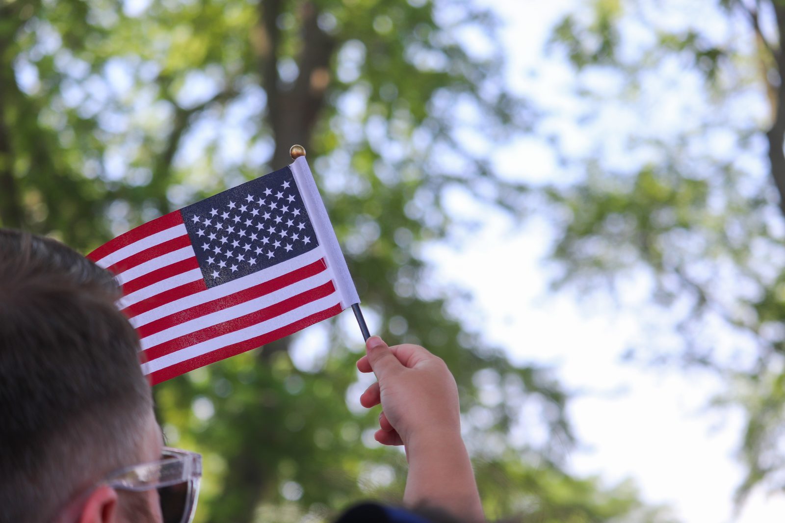 Guest waving a small American flag at Sauder Village