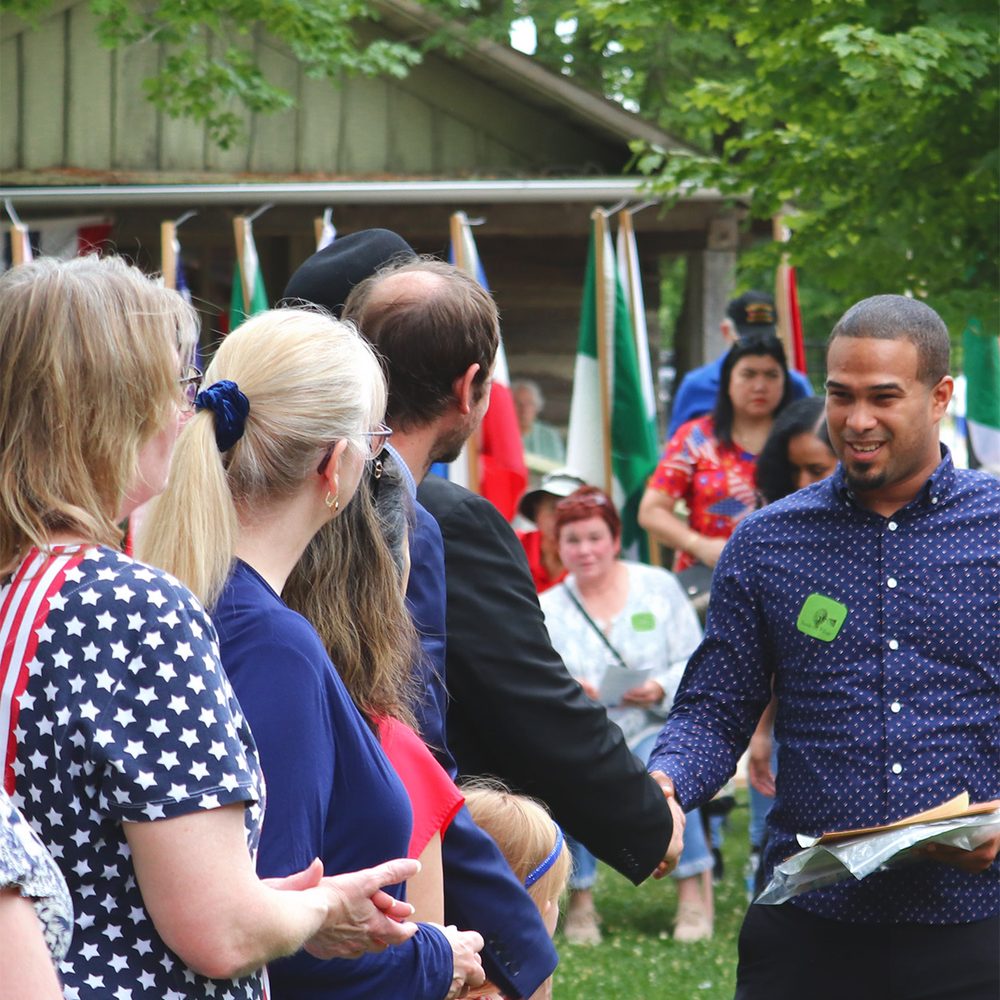 Crowd holding American flags at the Sauder Village naturalization ceremony